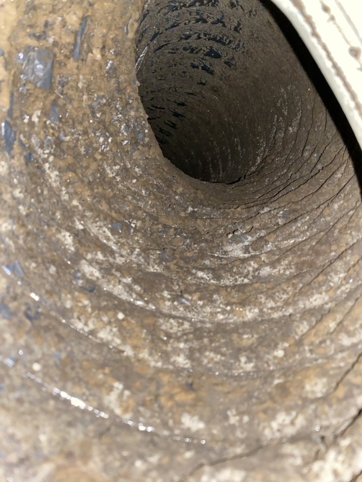 Dust and buildup inside a dirty air duct before cleaning